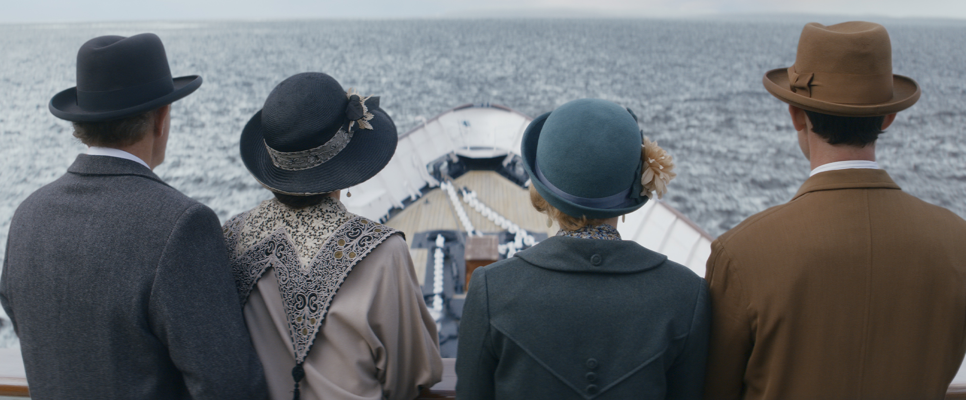 Four characters stand at the helm of a boat, looking out over the ocean