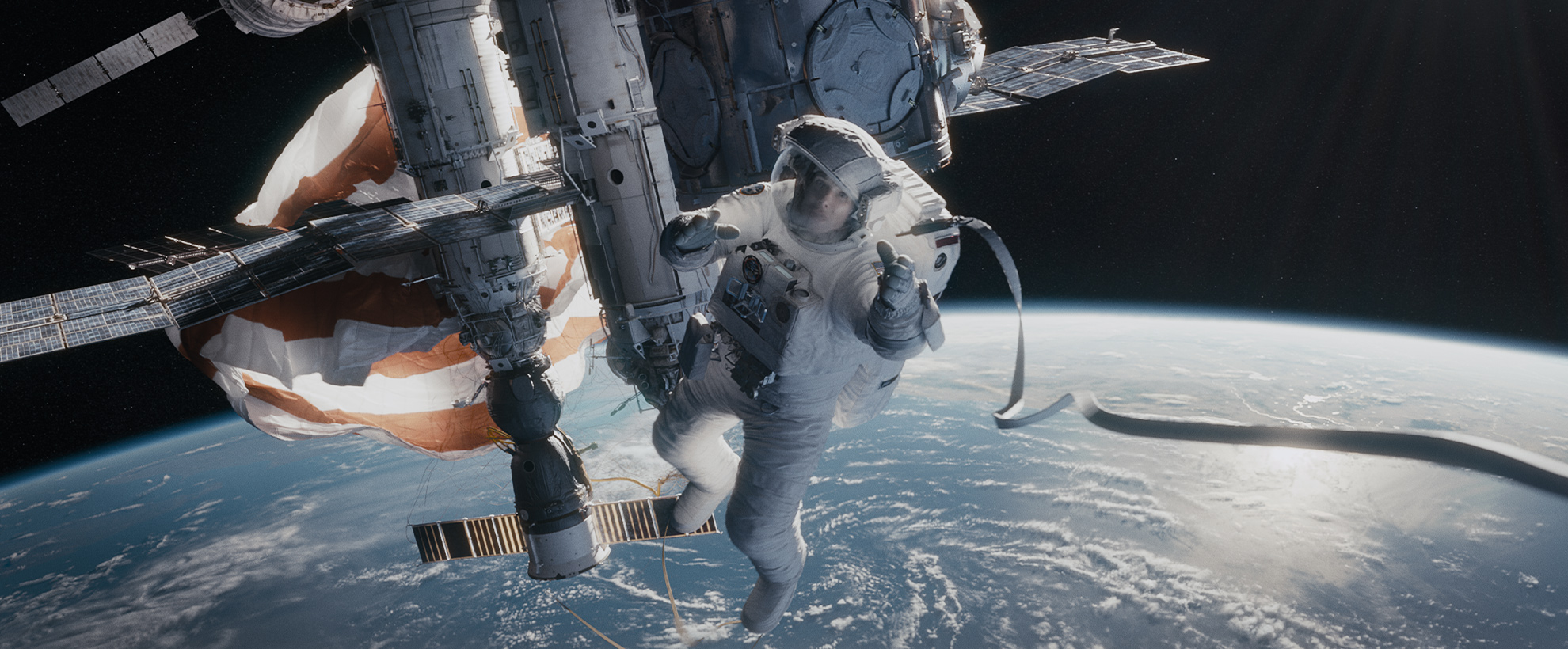 Sandra Bullock in Gravity, floating in space, reaching for a rope