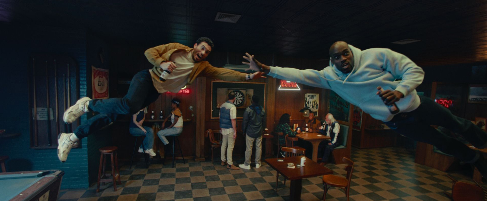 Two men leap sideways in a bar