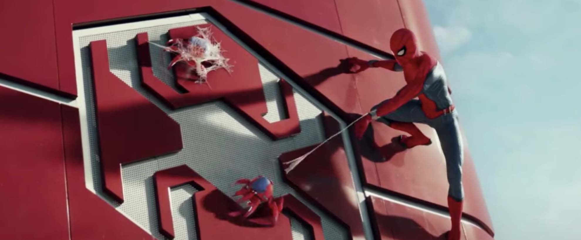 Spiderman scales the side of a building and shoots his web