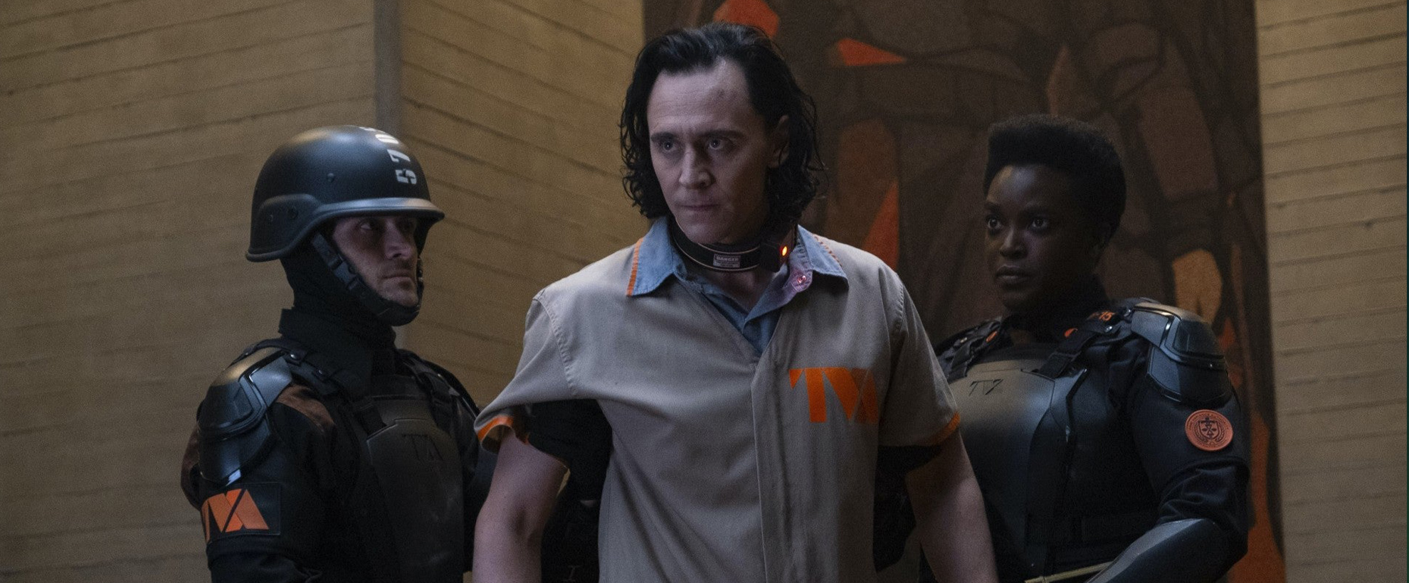 Variant Loki, being held back by two TVA employees in black uniforms