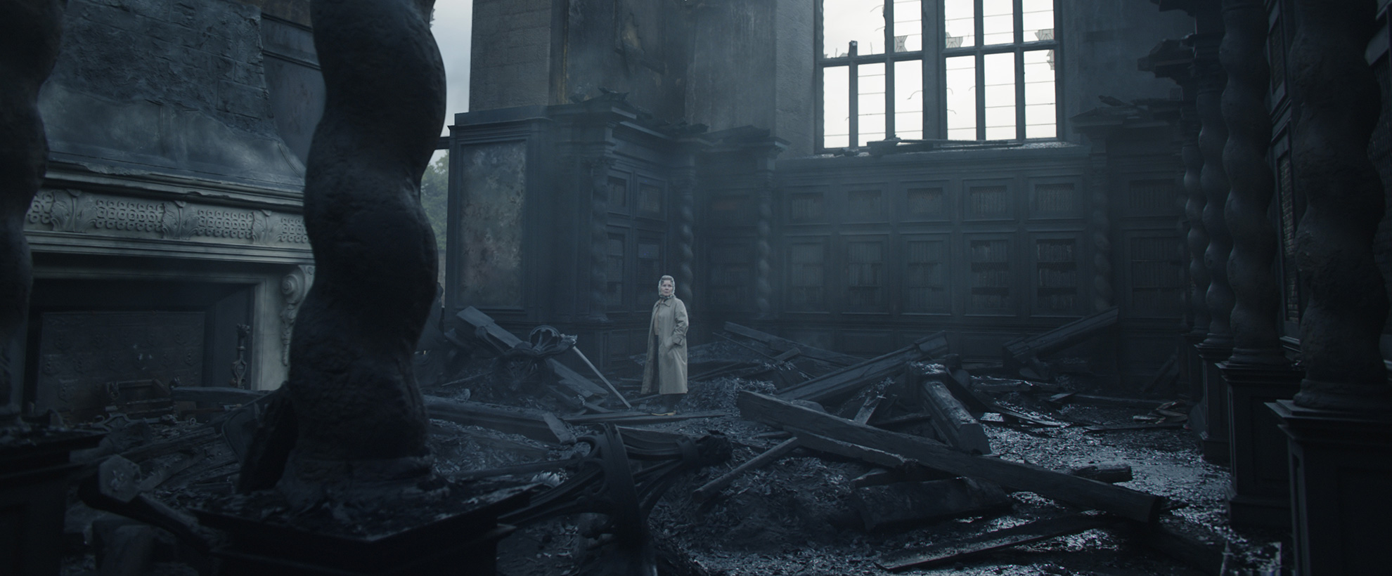 Imelda Staunton as the Queen, standing in the burned wreckage of the palace after a fire