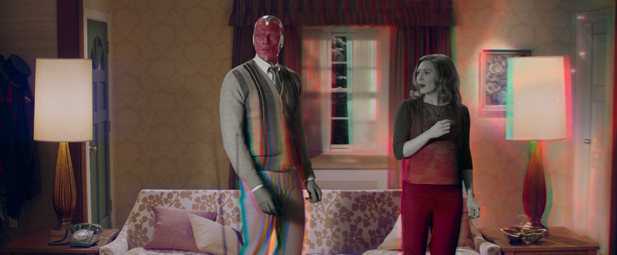 Wanda and Vision in their living room as it shifts from black and white to colour