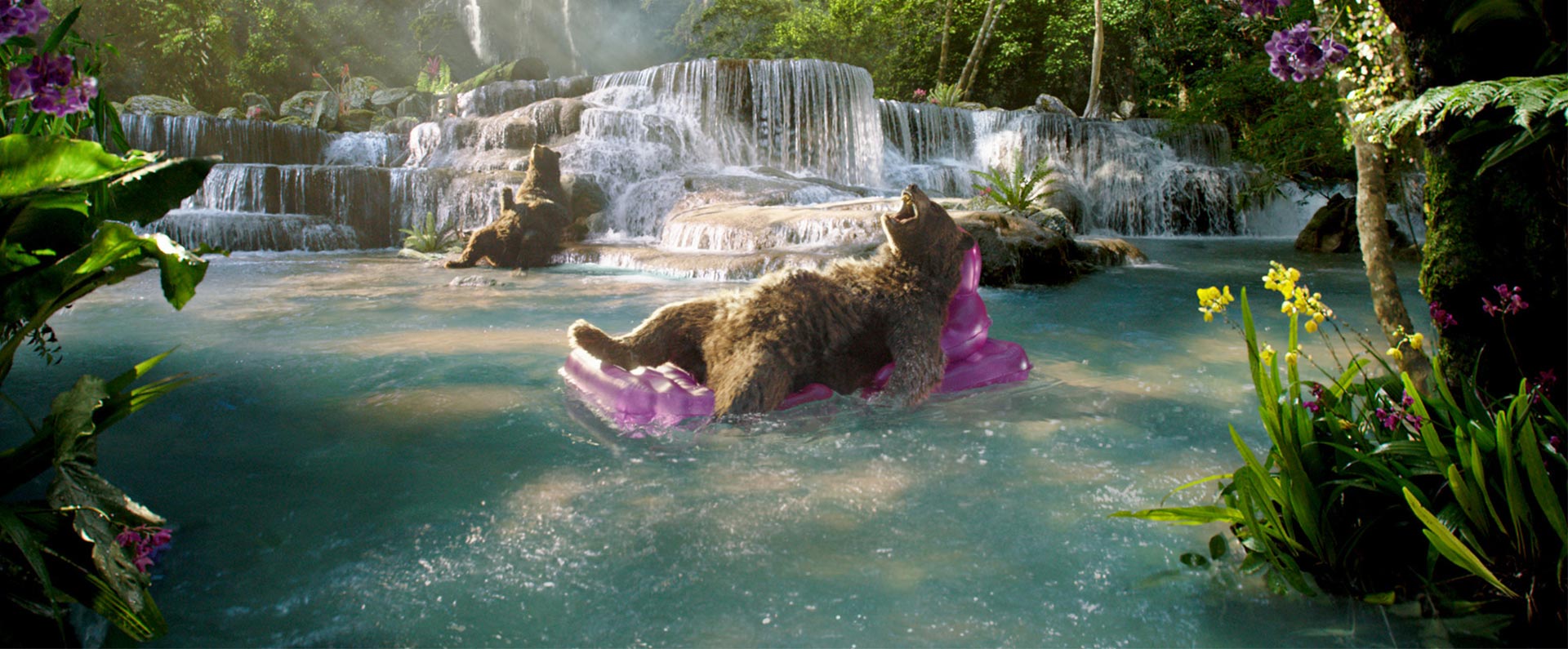 Bears on inflatables lounging in a lake an a waterfall