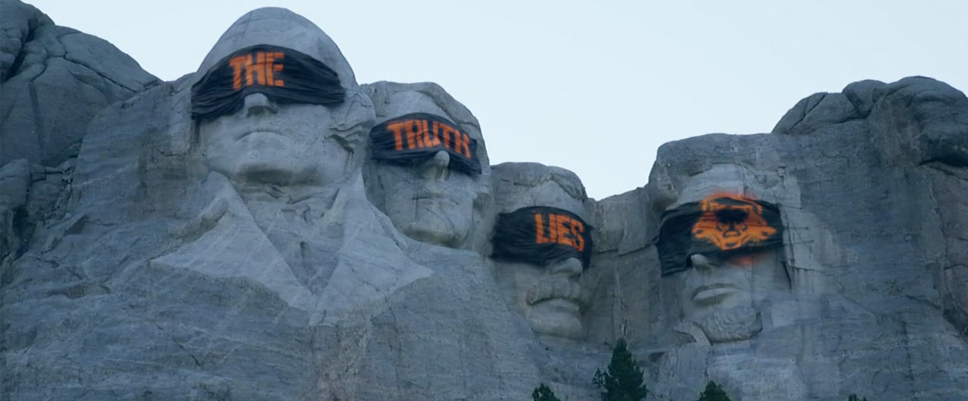 The presidents on Mount Rushmore blindfolded. The blindfolds are spray painted to create the phrase 'the truth lies'