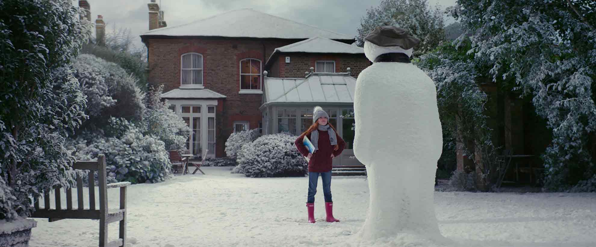 Girl and a snowman on a snowy day