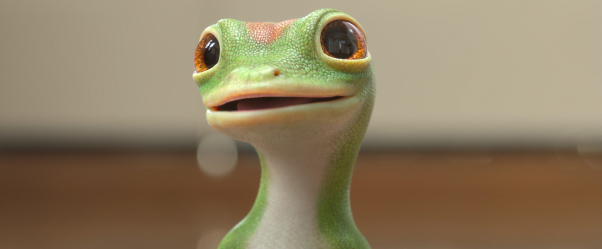 A close up of the CG animated GEICO Gecko who is standing with a grin on his face