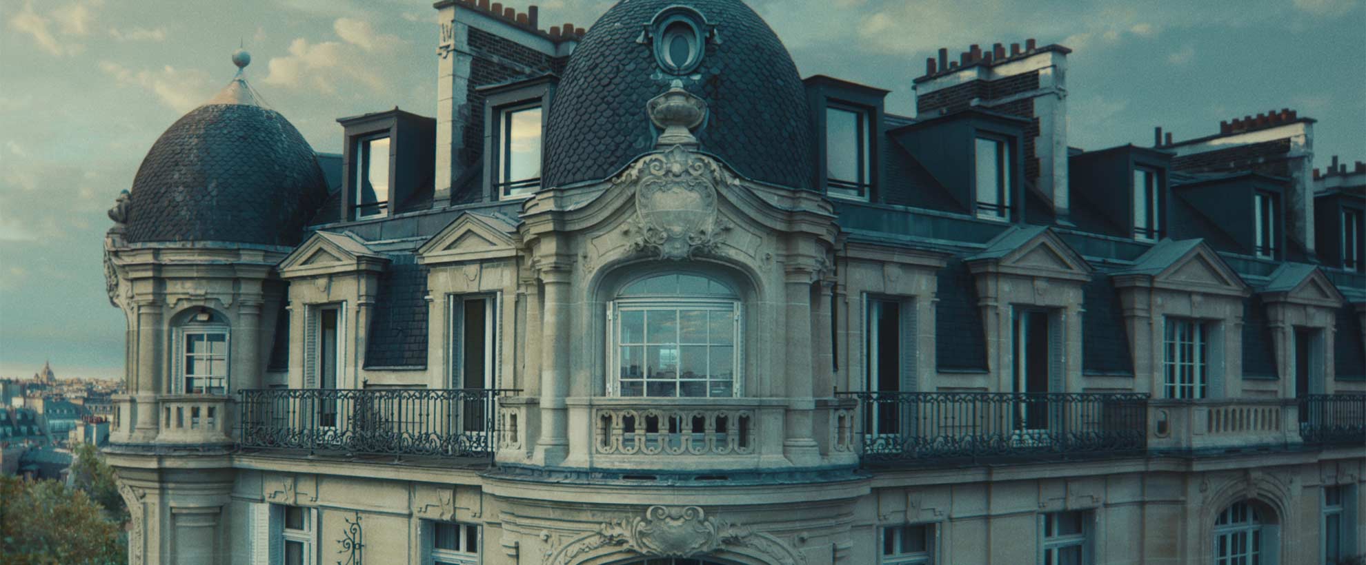 An exterior shot of the top floor of an elegant Parisian building