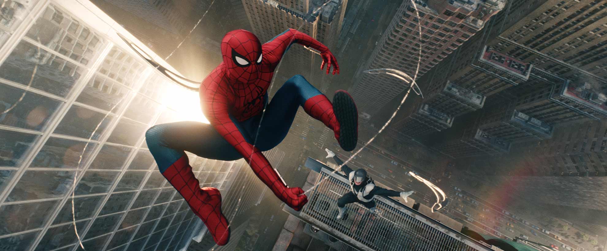 Spider-Man swings from building to building using webs
