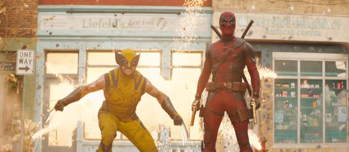 A still from Deadpool and Wolverine showing VFX explosions and the title characters in battle poses.