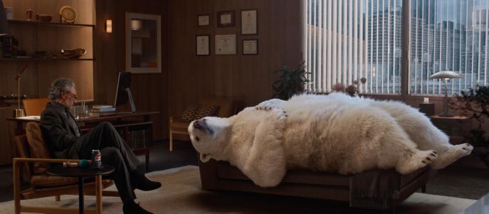 A CG animated polar bear lays on a therapists couch, his therapist (played by Taika Waititi) sits across sitting on a chair