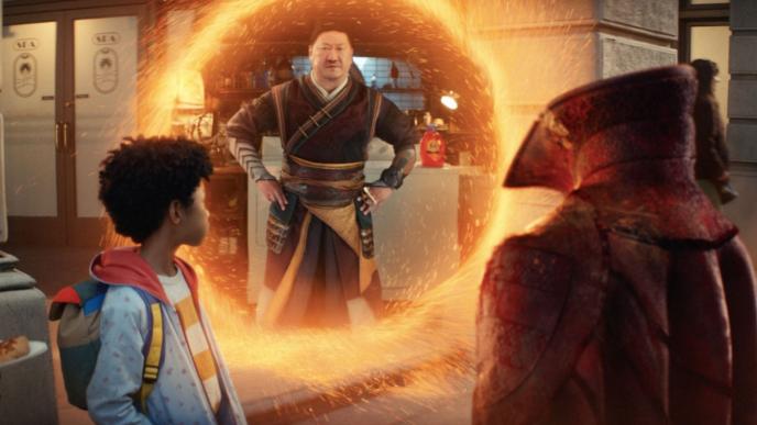 sorcerer supreme wong looking at doctor strange's cloak and a child through an inter-dimensional portal