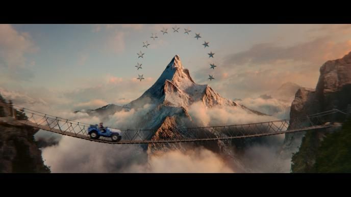 paramount mountain and star logo with a wooden bridge. there is a car driving on the bridge