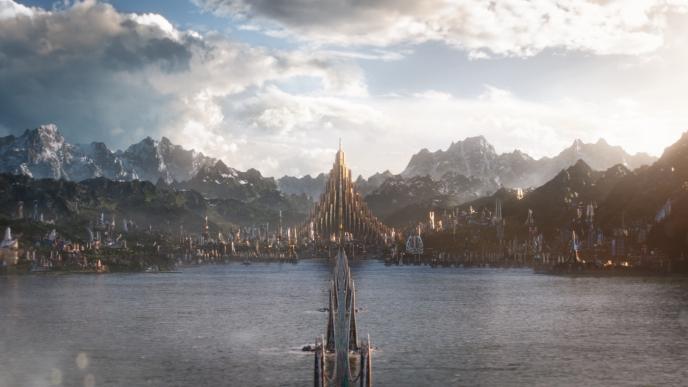 cg animated city of asgard overlooking a lake in front of mountains and cloudy skies