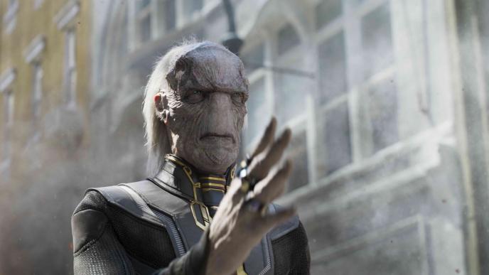close up of ebony war holding up his hand performing telekenisis as smoke emerges from the background