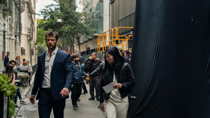 actor chris hemsworth and director anh vu walking together on a film set