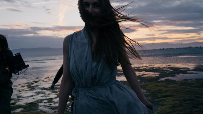 an actress smiling to the camera on a film set at the beach