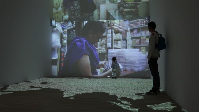 a father and small child watching an exhibition that is projected onto the walls