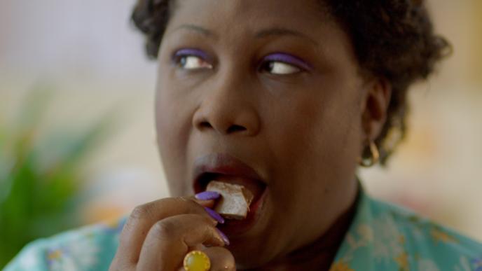 a person eating a piece of chocolate