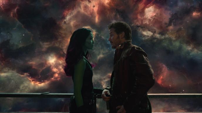 guardians of the galaxy characters gamora and star-lord looking at each other while standing at a balcony that overlooks the cosmos