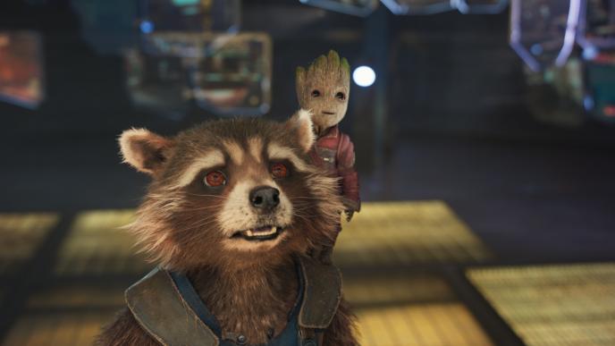 close up of rocket racoon and baby groot. baby groot is standing on rocket's shoulders as they are both looking up