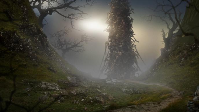 a tower made up of hundreds of skeletons in a forest with dead trees