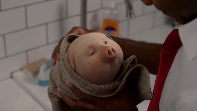 a person holding a cg animated photorealistic piggy bank wrapped in a towel