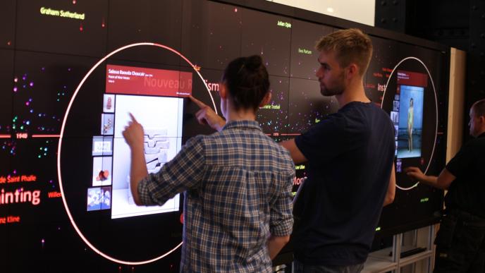 three visitors interactions with a modern art inforgraphic screen