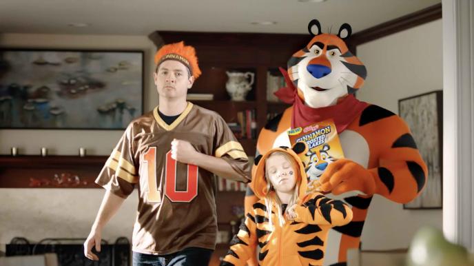 cg animation of tony the tiger holding up frosted flakes next to a person