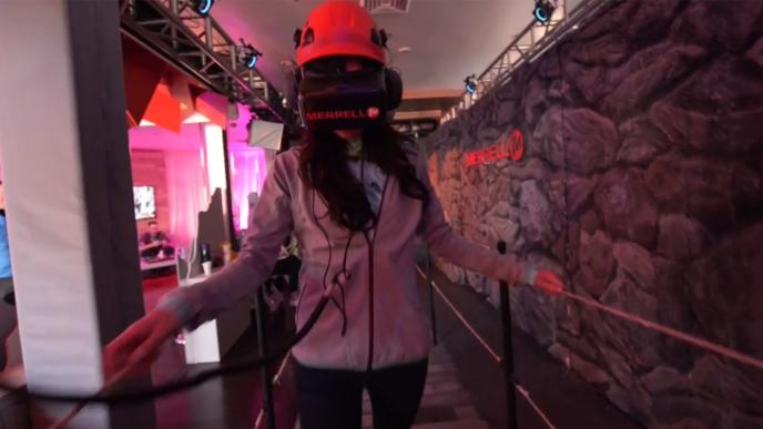 a woman wearing a vr headset walking through the trailscape experience