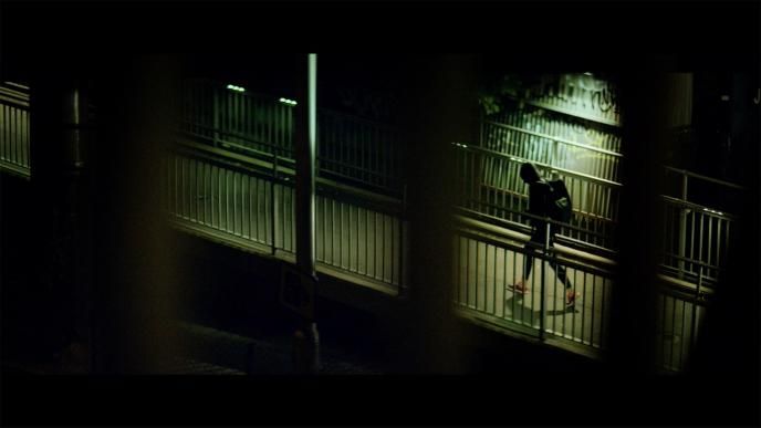 a swimmer in training gear walking through a dimly lit street