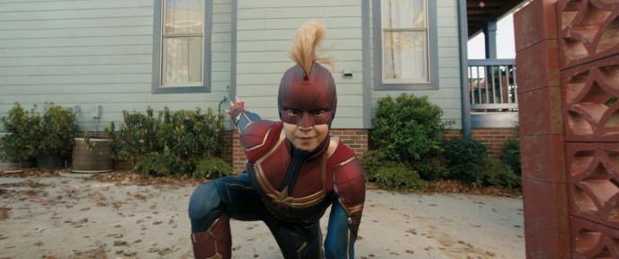Kamala Khan does a superhero landing, dressed as Captain Marvel