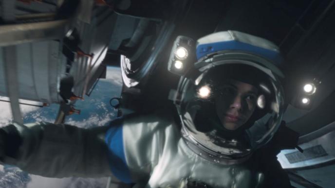 close up of an astronaut in space next to a space shuttle looking towards the right