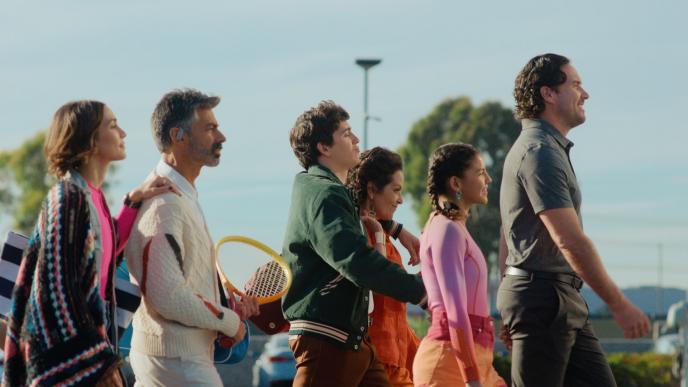 Marcello Hernández walks with a group of people in a parking lot