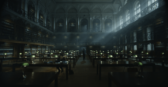 A person walks through a large dark library