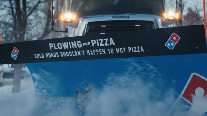 A snow plow that says "Plowing for Pizza Cold Roads Shouldn't Happen to Hot Pizza"