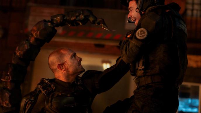 A villain with a CGI scorpion tail threatens a man 