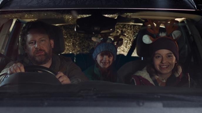 front view of a family in a car wearing christmas themed antlers
