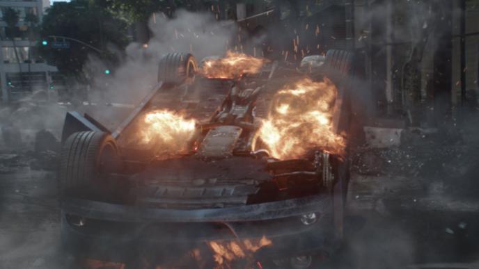 a flipped car that is on fire
