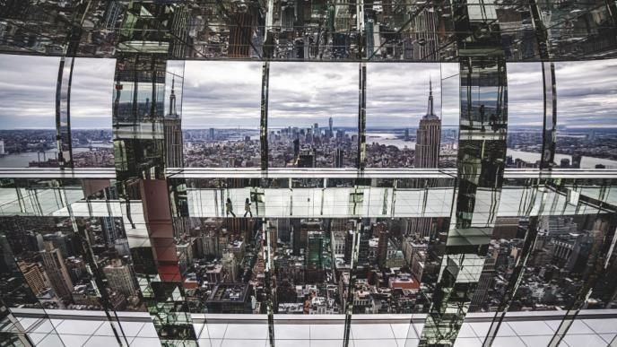 perspective from inside of a skyscraper looking out into the city that has been animated to look like the pillars of the building are mirrored and reflective of environment