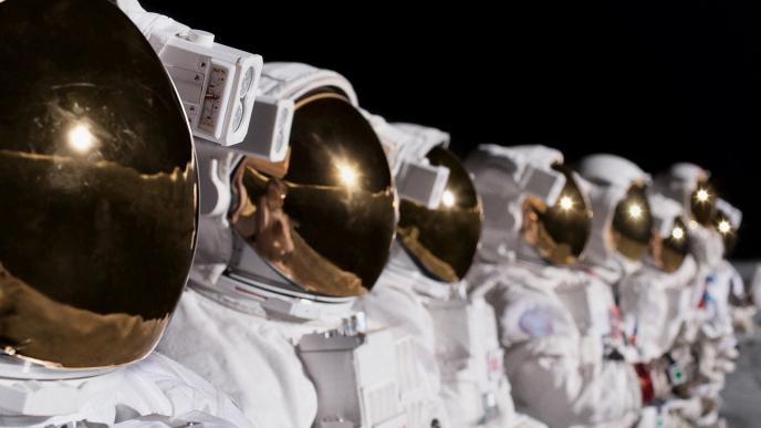 close up of astronauts in space suits and helmets