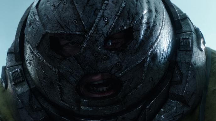 close up face shot of juggernaut character wearing an iron clad helmet from deadpool 2