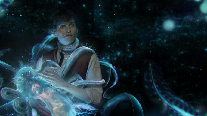 actor eddie redmayne as newt scamander bottle feeding a luminescent creature with sprouting alien-like tendrils