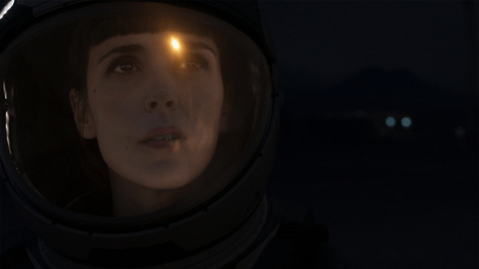 close up of an astronauts face looking up through a space helmet