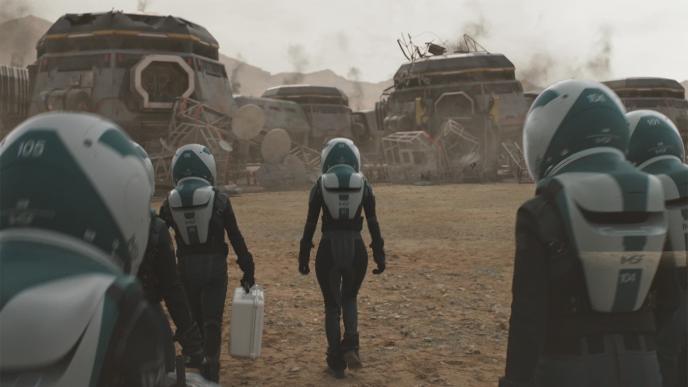 back view of six astronauts walking towards a station on planet mars