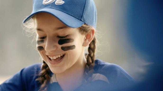a child smiling in a baseball cap