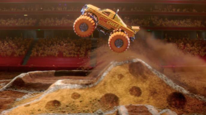 A yellow monster truck take off from a cheese ramp with a crowd in the background.