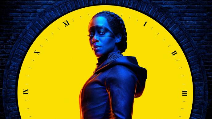 A promotional image of Regina King in Watchmen, in navy light against a bright yellow clock
