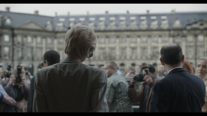 Elizabeth Debicki, playing Princess Diana walking towards paparazzi, with a green screen in the background, final shot