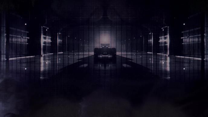 The silhouette of a formula 1 race car in a dark garage